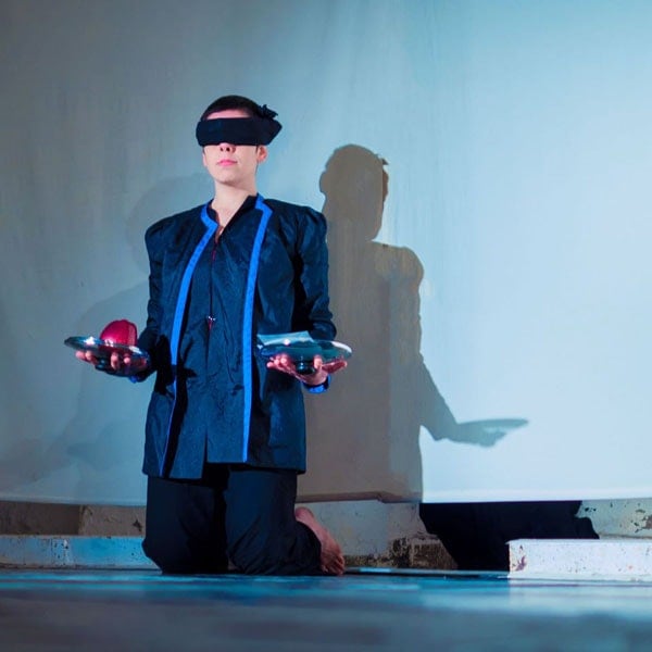 Photo of person blindfolded with apple in hand