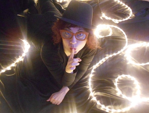 Foto einer Frau mit Brille, die direkt in die Kamera schaut und