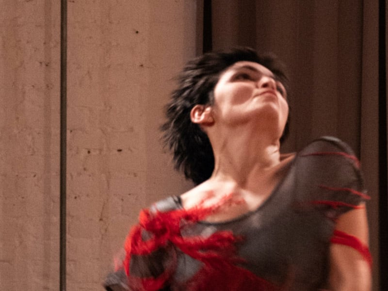 Nahaufnahme einer Frau in Bewegung, sie blickt nach oben, eine Schulter ist etwas hochgezogenen in einer tänzerischen Pose.