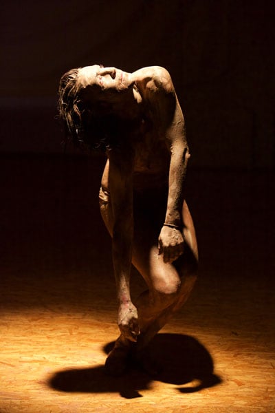 Foto eines halbnackten Tänzers in Pose im Bühnenraum. Spiel mit Licht und Schatten